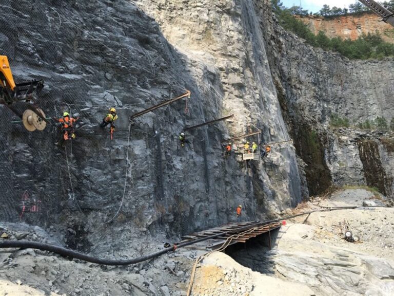 Workers installing rockfall mitigation drape